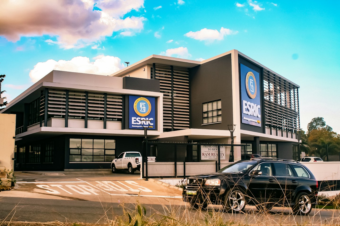 Modern commercial building with two blue signs under a blue sky.